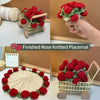 A bouquet of finished rose knitted placemats in red and green are displayed in a woven basket.