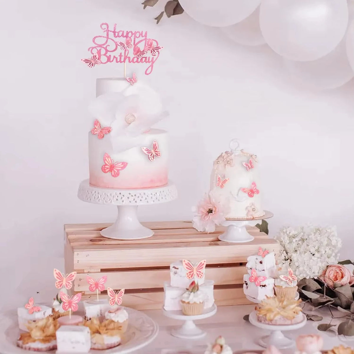 A tiered white cake decorated with pink butterfly toppers on a wooden surface.