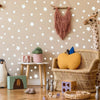 A wall decorated with white stars, a giraffe toy, and a woven basket with a yellow stuffed animal.