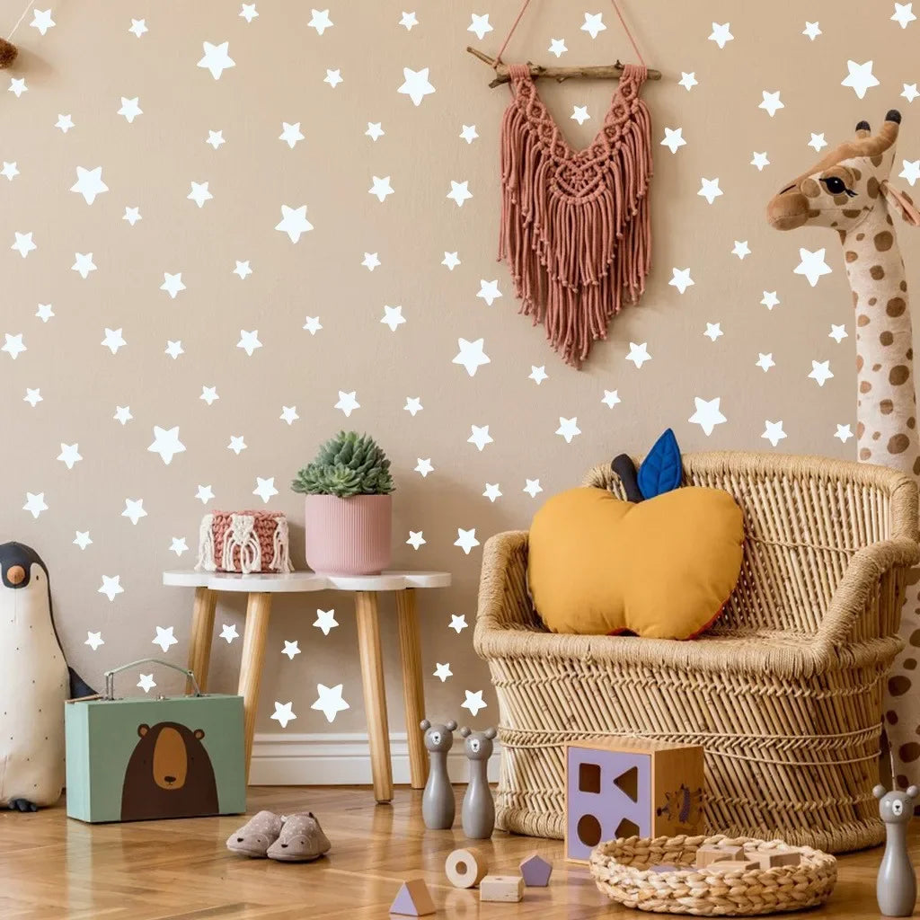 A wall decorated with white stars, a giraffe toy, and a woven basket with a yellow stuffed animal.