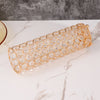 A long, cylindrical vase covered in gold wirework and clear crystals for elegant home decor.