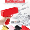 A red money gun toy is shown being held, with various stacks of fake money scattered around it.