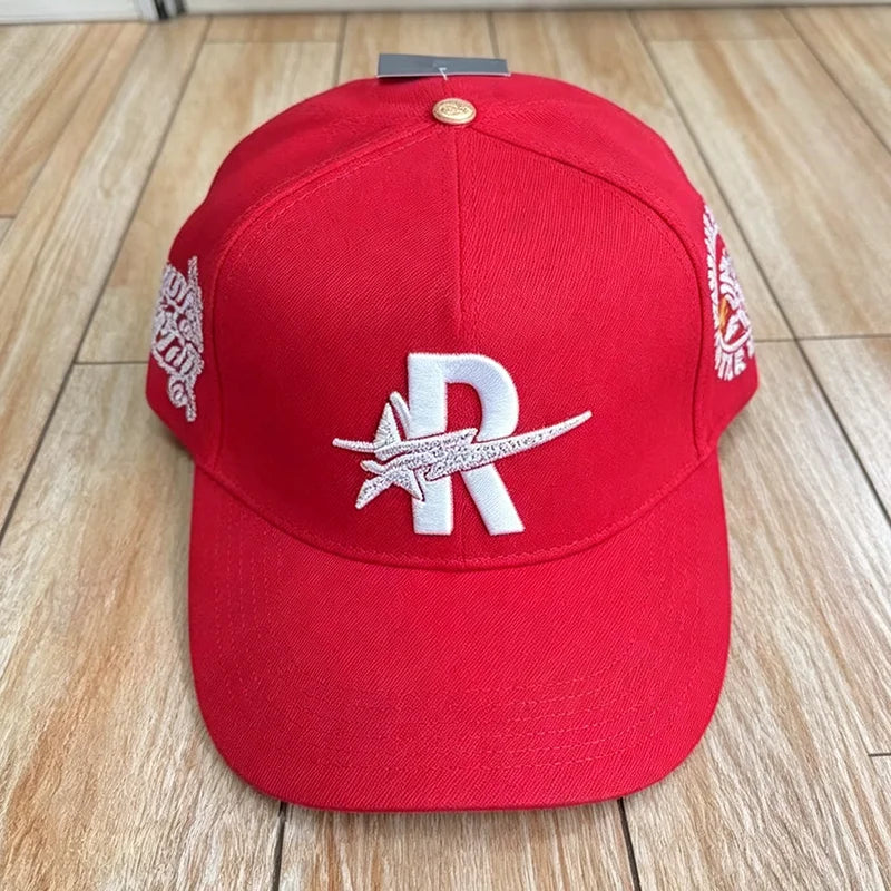 A red baseball cap embroidered with a white star and the letter R on the front.