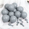 A cluster of gray latex balloons on white fabric for celebrations.