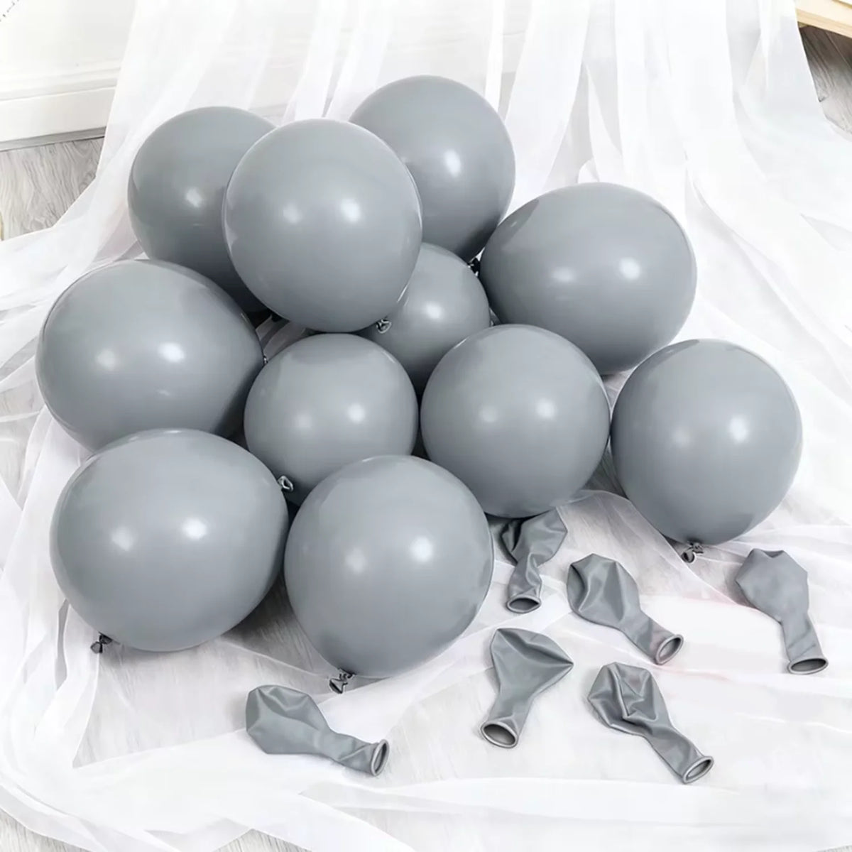 A cluster of gray latex balloons on white fabric for celebrations.