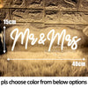 A glowing neon sign spelling out Mr & Mrs on a textured wall with golden fur carpeting.