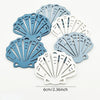 A set of twelve wooden ocean ornaments shaped like shells, scallops, and starfish in shades of blue and white.
