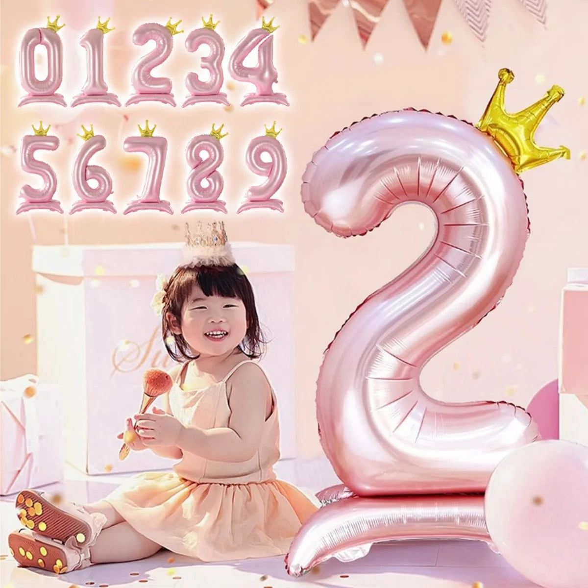 Pink aluminum foil crown number balloons spelling out the number 2 with a smiling child