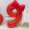 A large red foil number balloon shaped like the number 2, tied with a matching red bow.