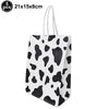 Five black and white cow print foil balloons for farm-themed birthday parties