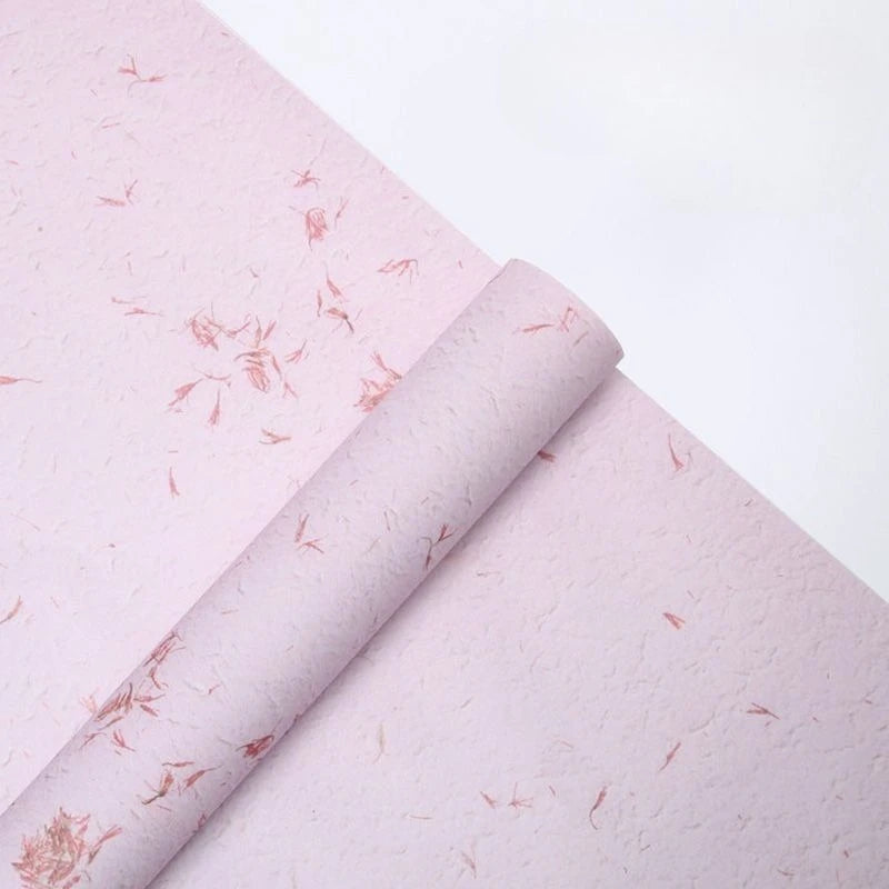 Roll of pink decorative packaging paper with subtle floral patterns