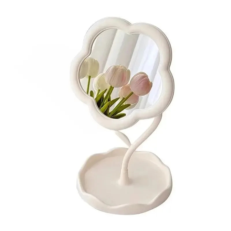 A white floral decorative mirror with a scalloped frame and a pedestal base.