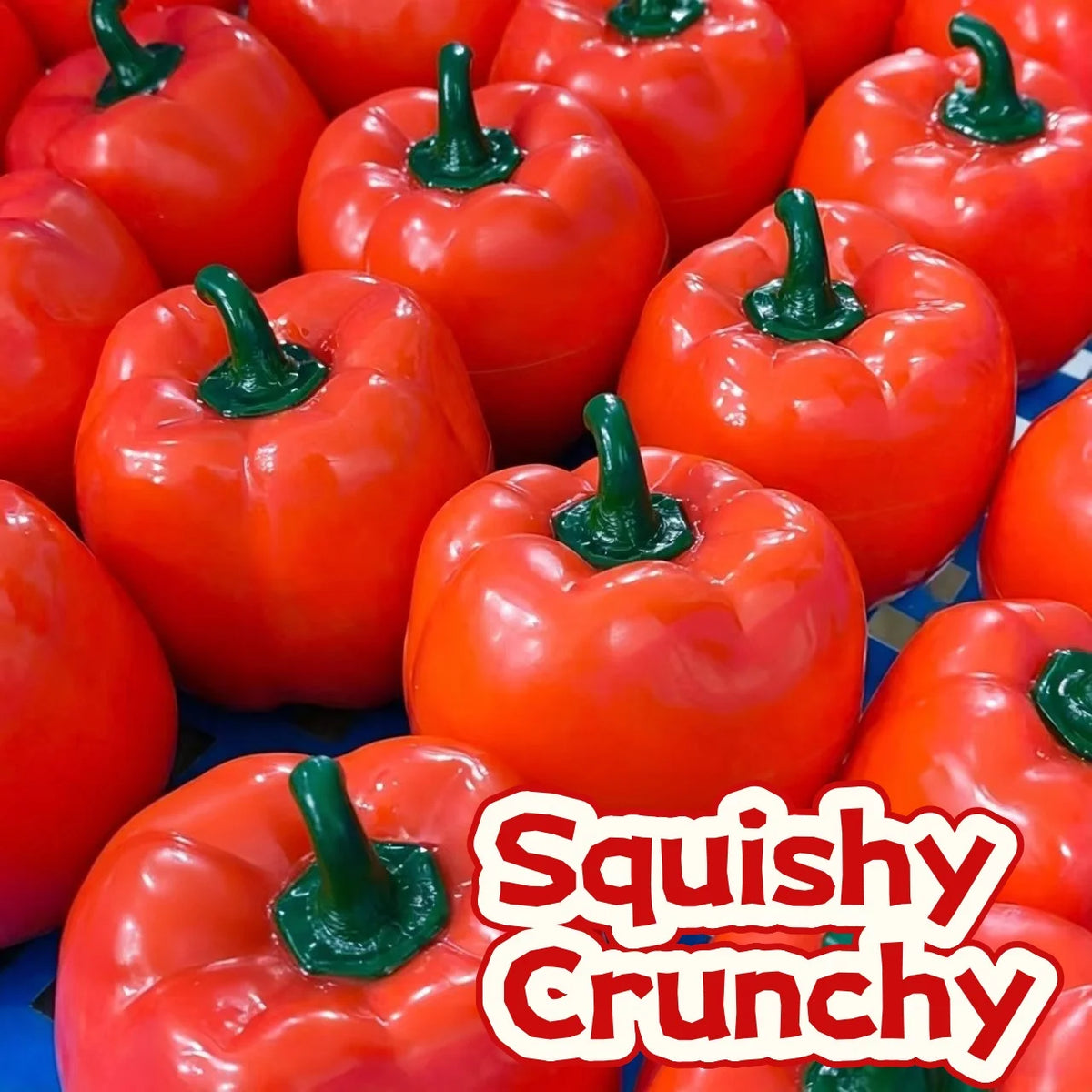 A close-up of several bright orange bell peppers used as squishy crunchy stress relief blocks.