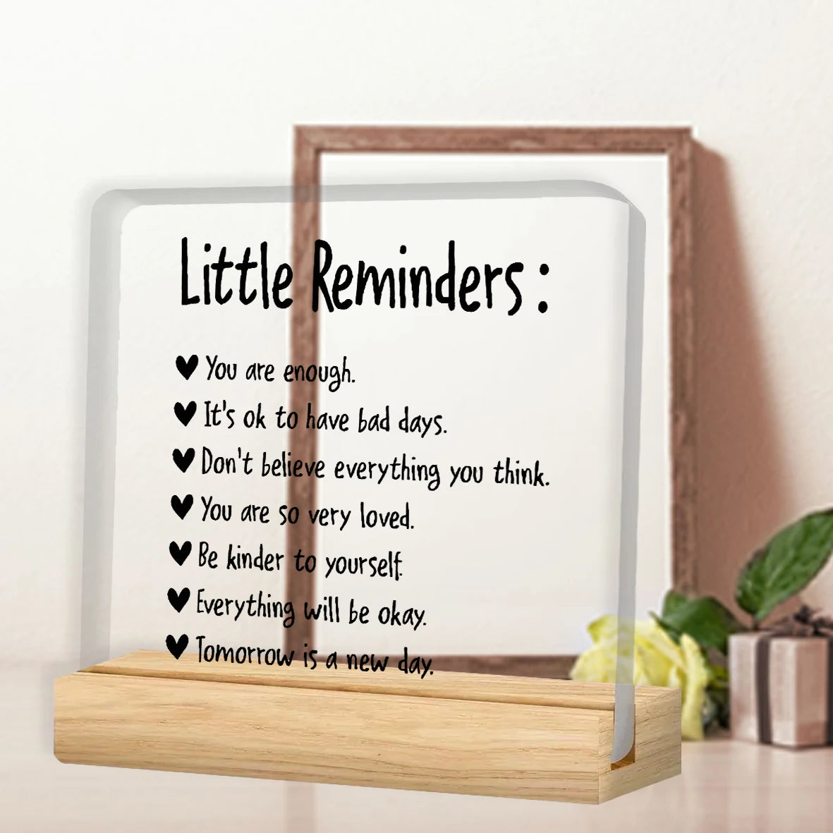 A framed acrylic desk plaque with a motivational sign listing positive affirmations like You are enough and Be kinder to your