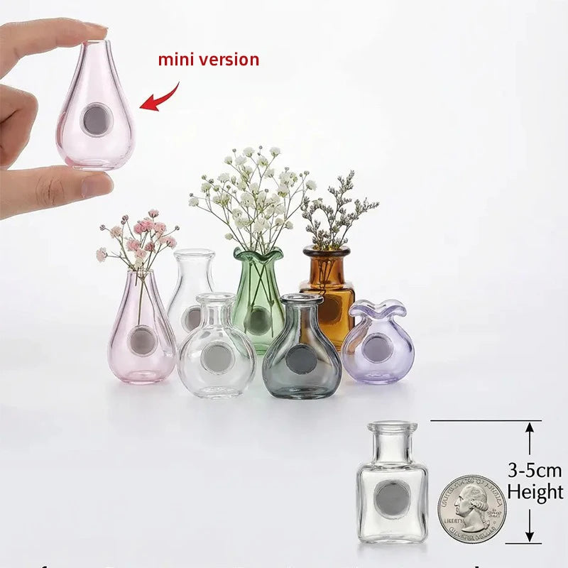 Eine Sammlung verschiedener Glasflaschen und eine Miniaturversion sind auf einer weißen Fläche mit einer Münze als Maßstab au