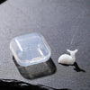 A clear plastic container holds a white resin ornament shaped like an elk or deer.