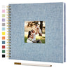 A blue linen cover scrapbook album with a photo of a couple embracing in a park.