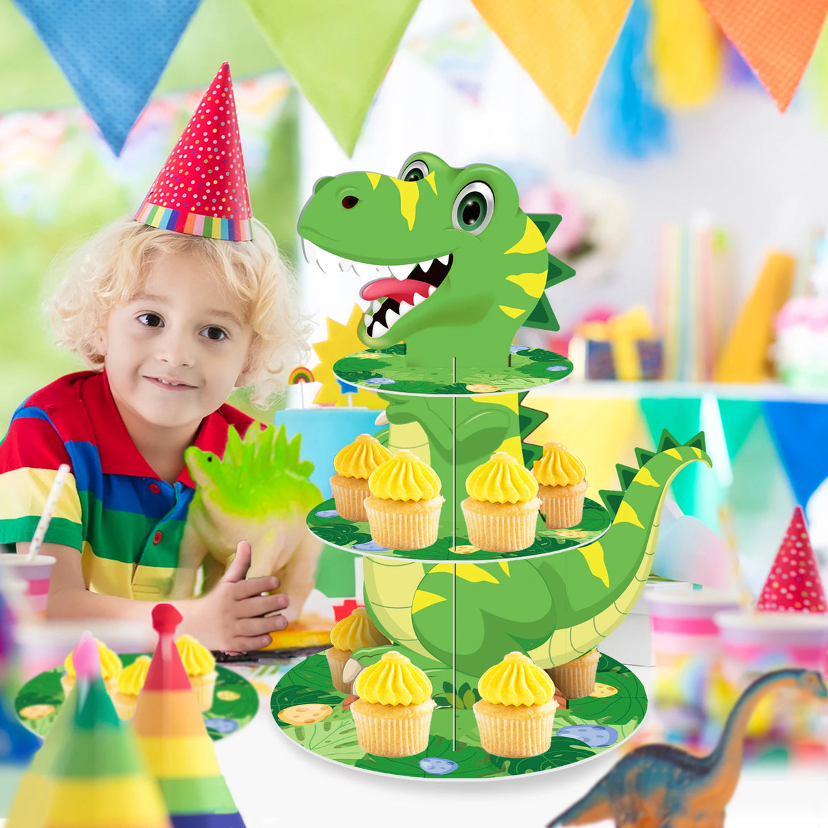 A green dinosaur-shaped 3-tier cupcake stand decorated for a kids party