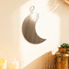 Gold moon acrylic wall mirror hanging on a beige wall with sunlight streaming through.