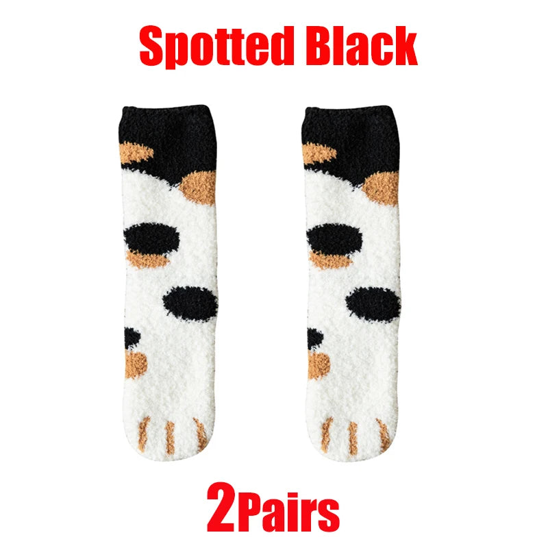 A pair of spotted black cat paw print plush socks shown against a white background.