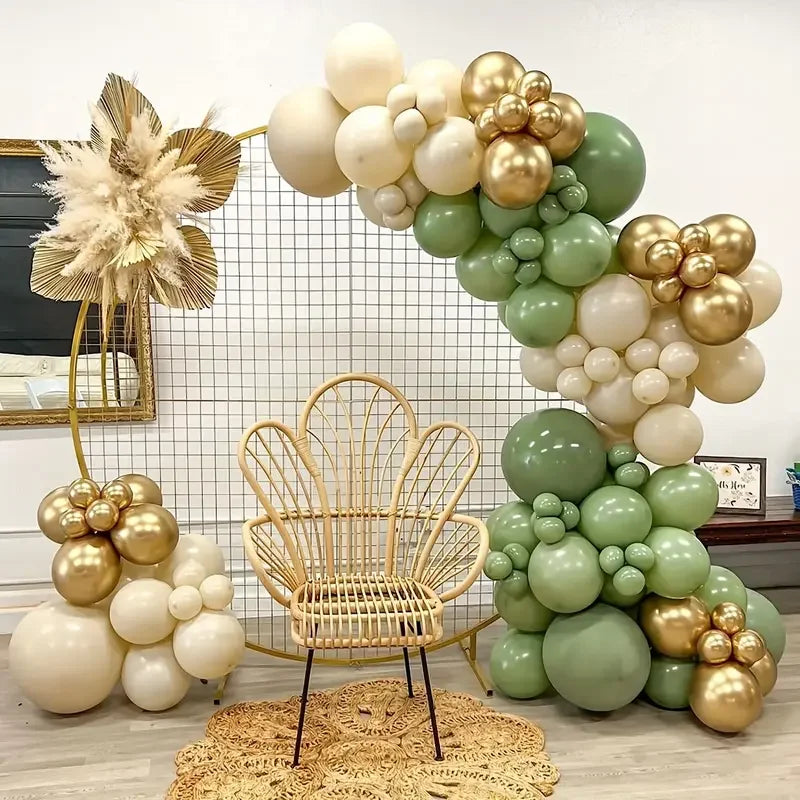 A display of various pastel and metallic colored balloons, including white, gold, and sage green, arranged in clusters.