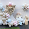 A large arrangement of pastel blue and pink latex balloons forming a curved shape against a white background.