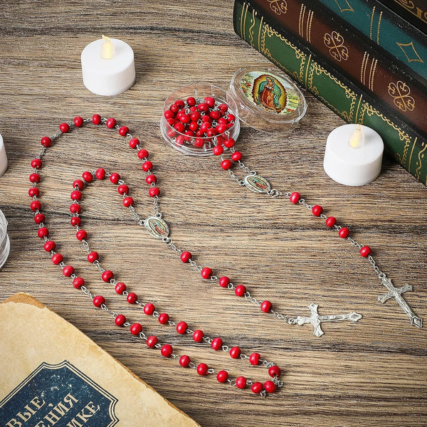 A necklace featuring a vintage rose carved cross on a wooden bead chain laid out on a wooden surface.