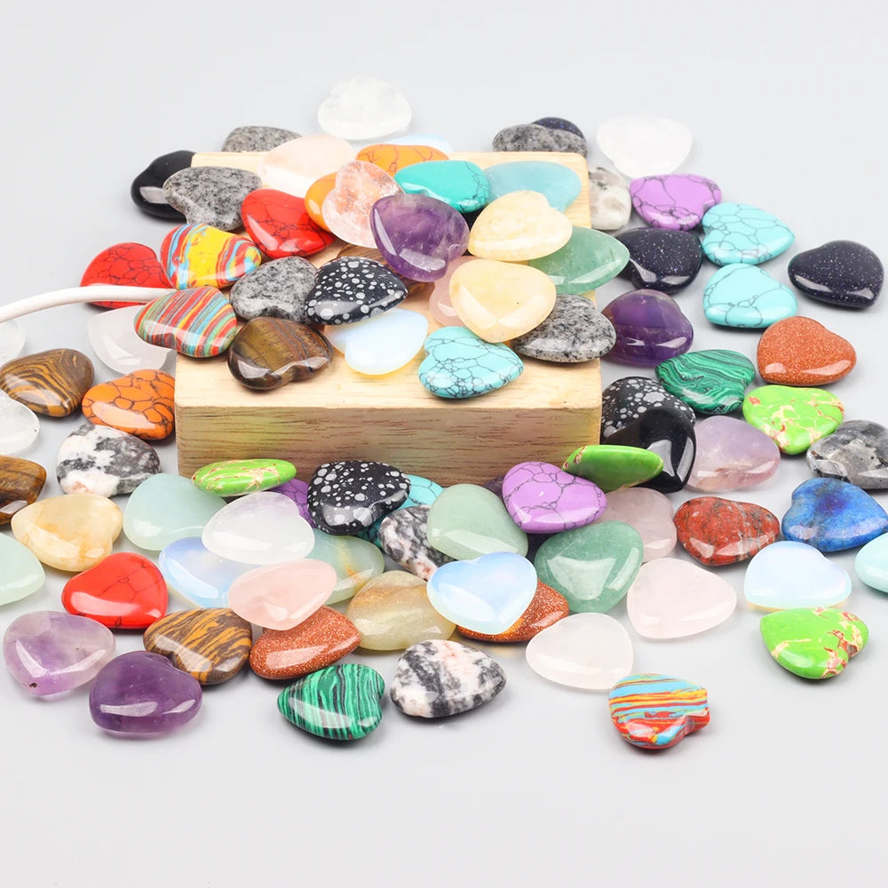 A collection of heart-shaped amethyst crystal stones in various colors scattered on a wooden surface.