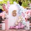 Fondo de arco de globos rosa y azul decorado con diferentes tonos y toques florales para un evento.