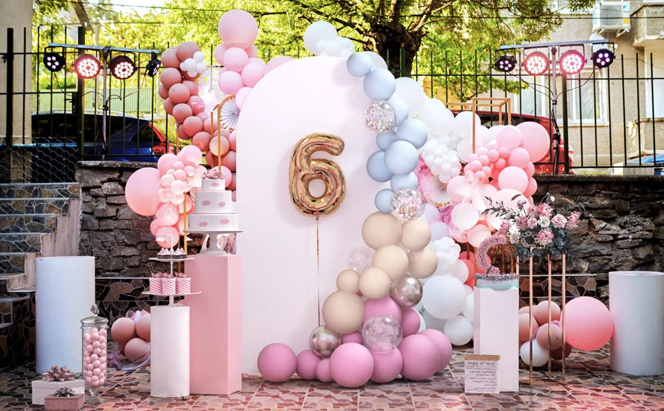 Fondo de arco de globos rosa y azul decorado con diferentes tonos y toques florales para un evento.