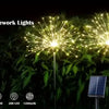 Solar fireworks garden lights illuminating green foliage at night.