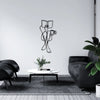 Black line art wall decor featuring two figures holding an open book on a white round table in a modern living space.