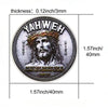 A silvery commemorative faith cross coin featuring the name Yahweh and a depiction of Jesus.