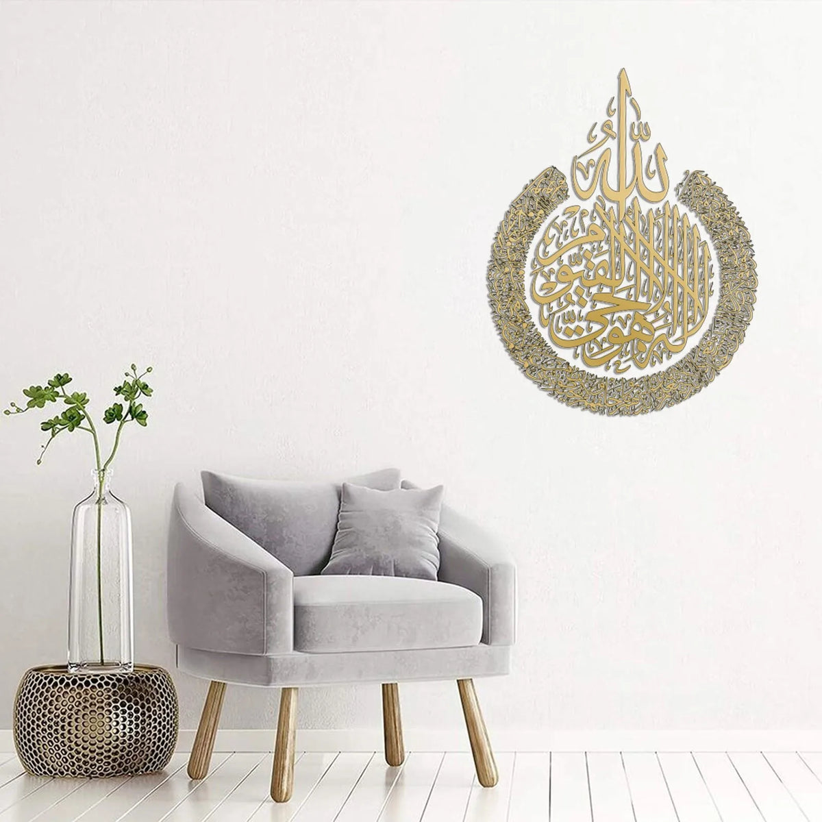 Moderner grauer Sessel mit Glasvase und einem Ayatul Kursi Wandsticker an einer weißen Wand.