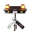 A black classic car headlight key holder with illuminated LED lights and attached keys.