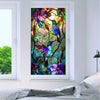 A close-up of a stained glass window film featuring vibrant purple and green hummingbird floral designs.