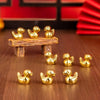 A set of small golden duck resin statues arranged on a wooden plank and surface.