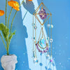 A hanging amethyst crystal suncatcher with golden accents and multiple dangling blue and purple crystals.