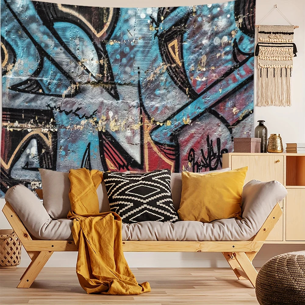 A large abstract graffiti tapestry featuring blue, black, and gold paint strokes hanging on a wall.