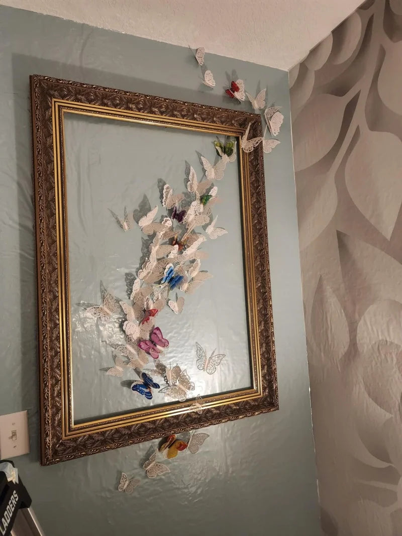 Gerahmtes Bild mit einem Blumenarrangement aus Papiermäusen an einer hellgrünen Wand.