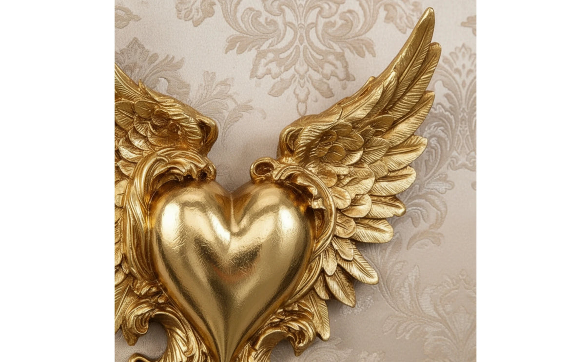 Gold ornate winged heart wall decor featuring detailed feather texture