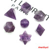 A set of seven amethyst crystals cut in various platonic geometric shapes and angles.