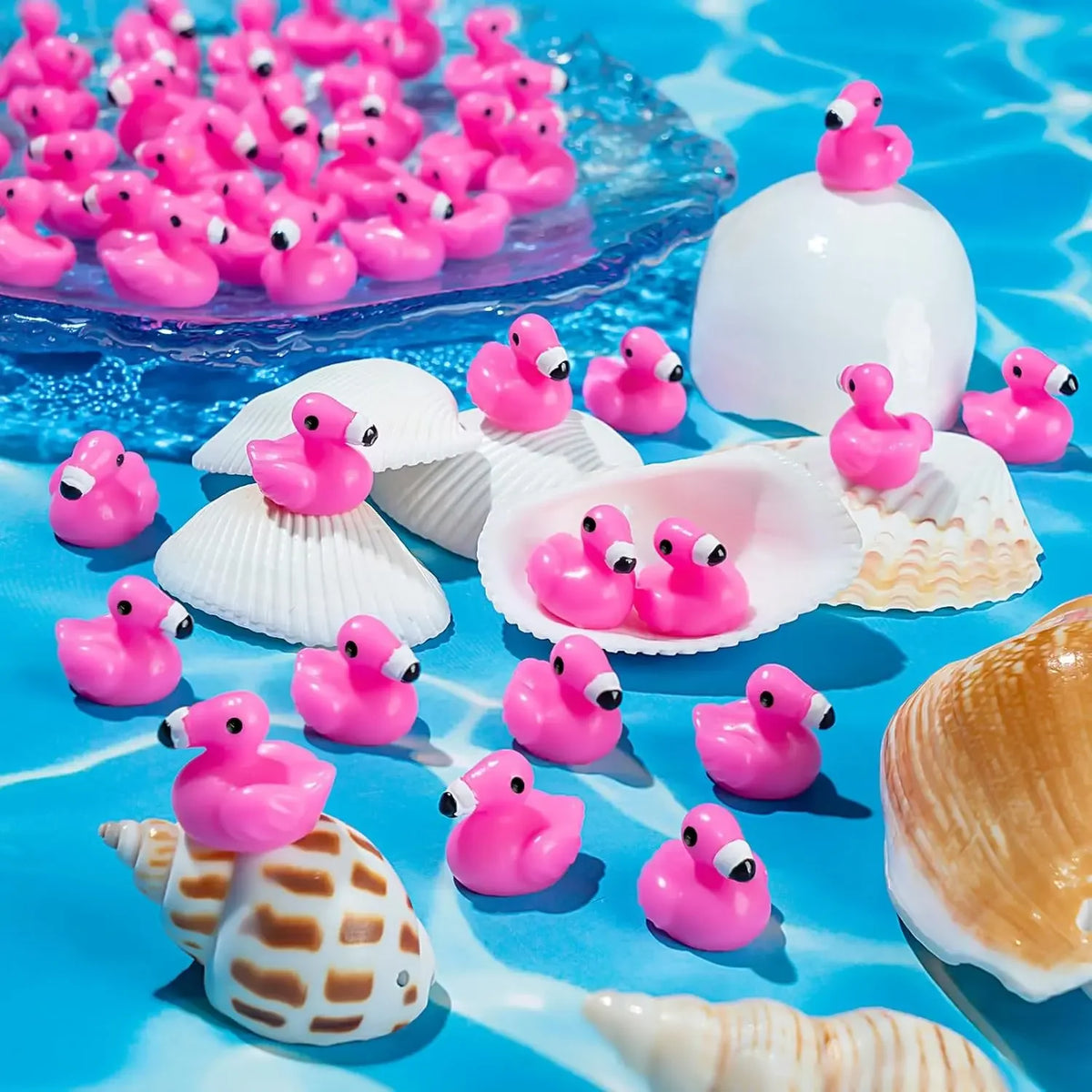 A collection of pink and white miniature resin flamingo duck figurines scattered on a blue surface.