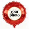 A red foil balloon shaped like a heart with a circular sticker that reads your photo