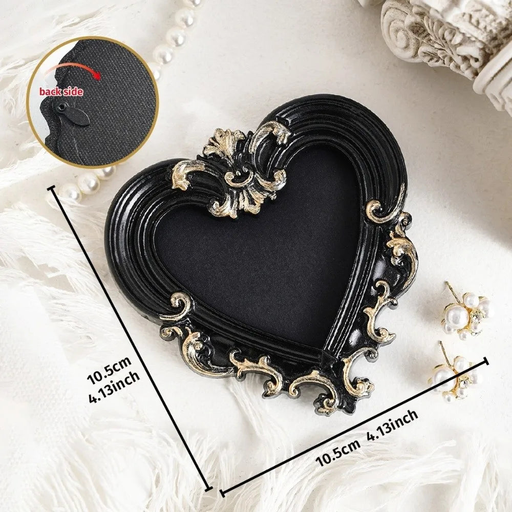 A black vintage baroque resin heart-shaped photo frame with gold accents shown on a white surface.