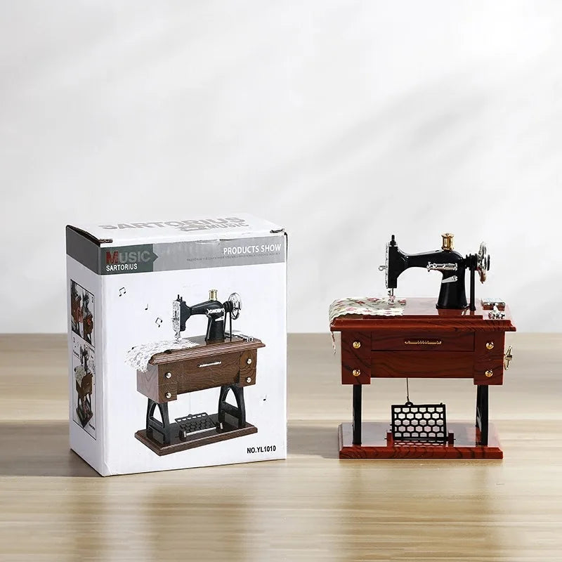 A vintage miniature sewing machine is displayed on a wooden box, suggesting a retro music box product.