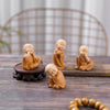 A collection of small, tan resin monk figurines arranged on a wooden surface.