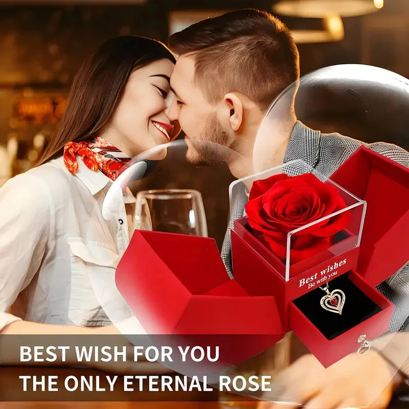 A couple shares a tender moment while a red rose is presented in an open gift box.