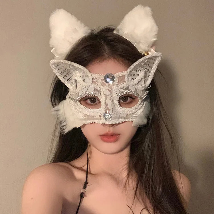 A woman wearing an elegant white lace half-face mask with fluffy ears and sparkling details.