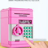 A pink smart password-protected lock piggy bank with a numeric keypad being operated by a finger.